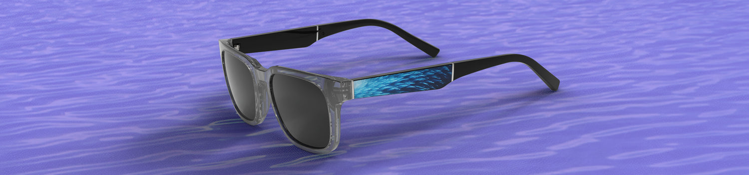 Sunglasses with a blue and black design on a blue water-like background