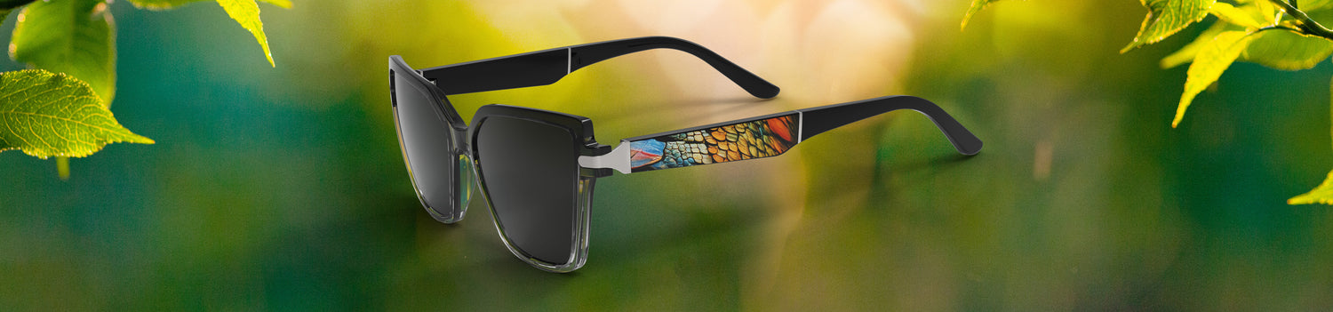 Sunglasses with a colorful brand logo on a green leafy background