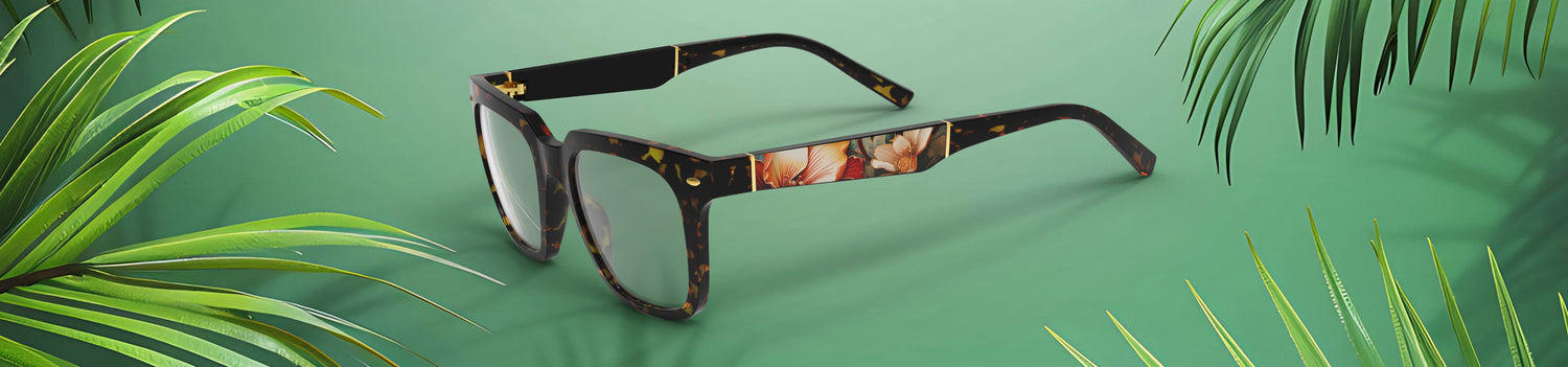 Glasses with a tortoiseshell frame on a green background with leafy elements
