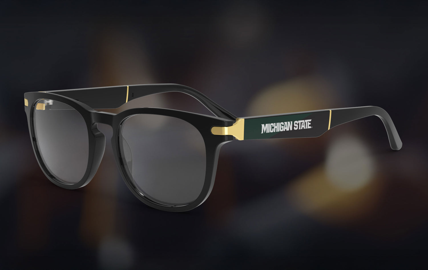 Black sunglasses with 'Michigan State' branding on a dark background