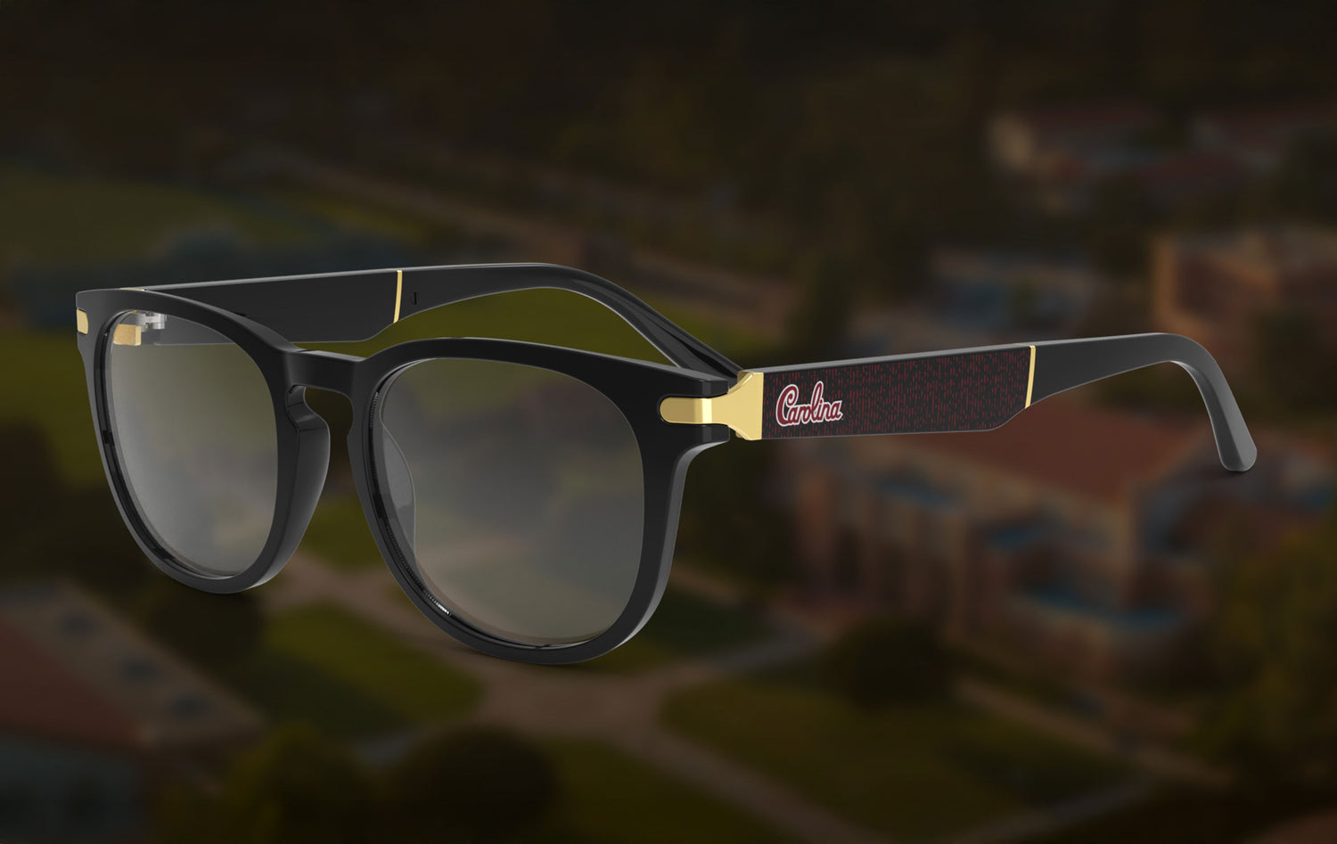 Sunglasses with black frames and gold accents on a blurred background that feature the South Carolina University Logo