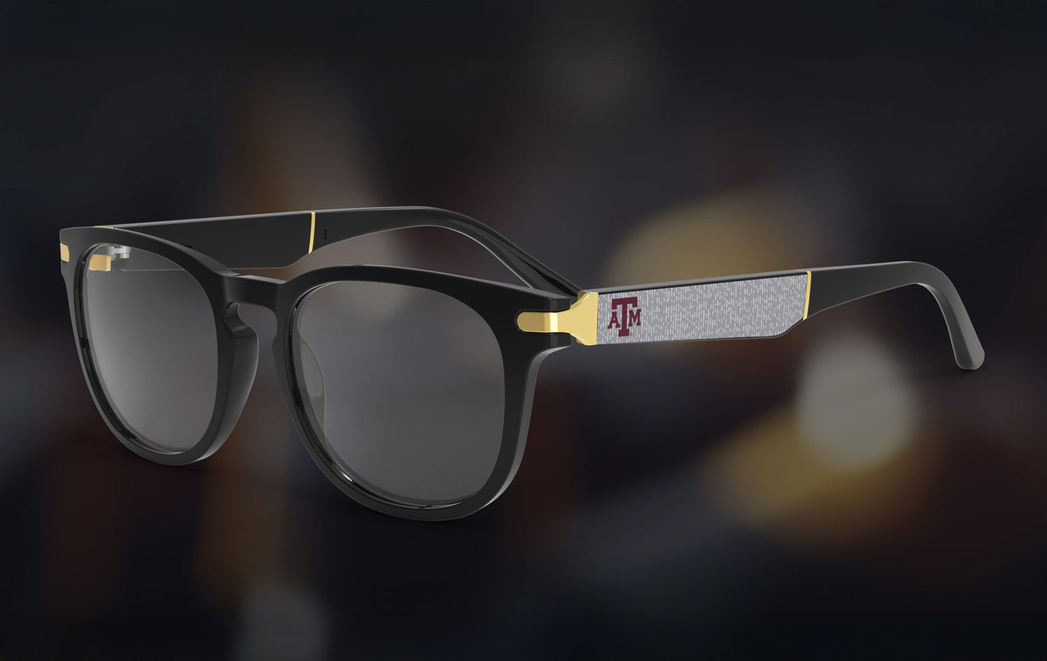 Black eyewear with gold accents and a Texas A&M University logo on a dark background