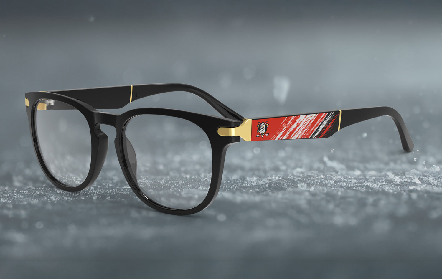 Black eyeglasses with red and gold accents on a gray background