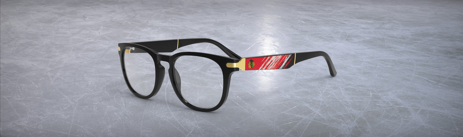 Black eyeglasses with red accents on a gray textured icy background