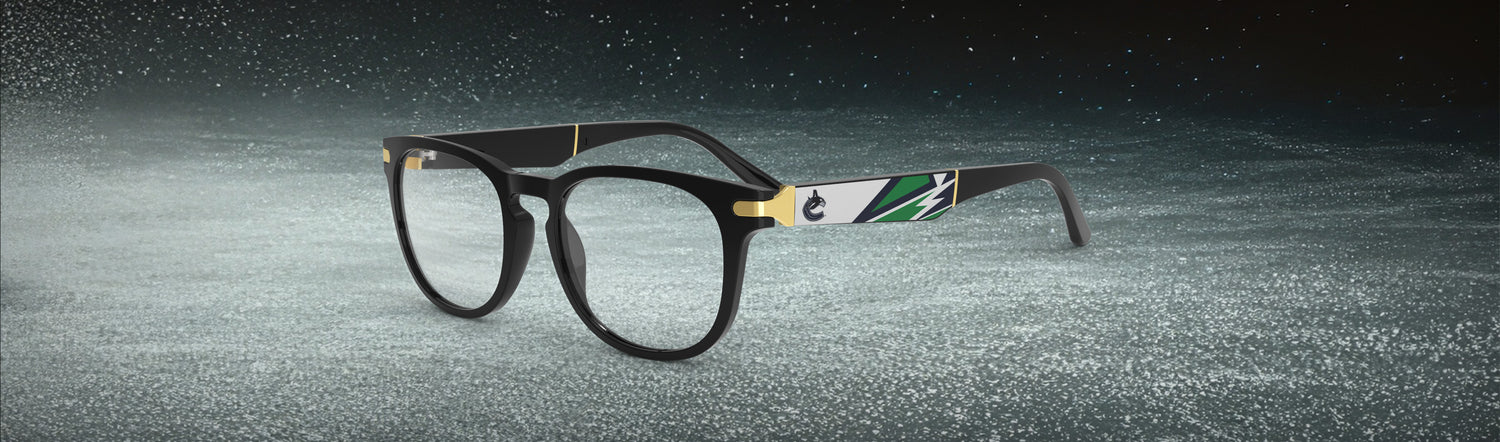 Allegiant glasses with temple blade showing Vancouver Canucks logo against a black and green abstract design in a hockey rink setting.