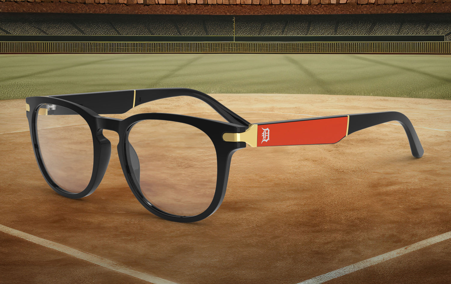 Black-framed glasses with and orange blade featuring the Detroit logo against a baseball field background 