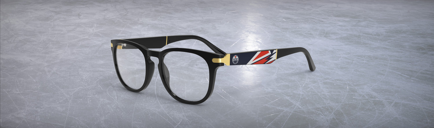Allegiant glasses with temple blade showing Edmonton Oilers logo against a black and blue abstract design in a hockey rink setting.