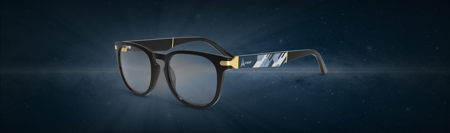 Allegiant eyeglasses with a temple blade showing a white USSF logo on blue abstract design against a blue backdrop.