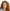 Woman with red hair and glasses looking directly at the camera on a white background